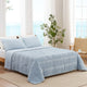 Snuggle Sac Cooling comforter in blue on bed in a bedroom with windows,plant and a view behind
#color_Blue