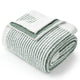 Rolled-up blanket with a brand logo on a white background #color_Green/Cream