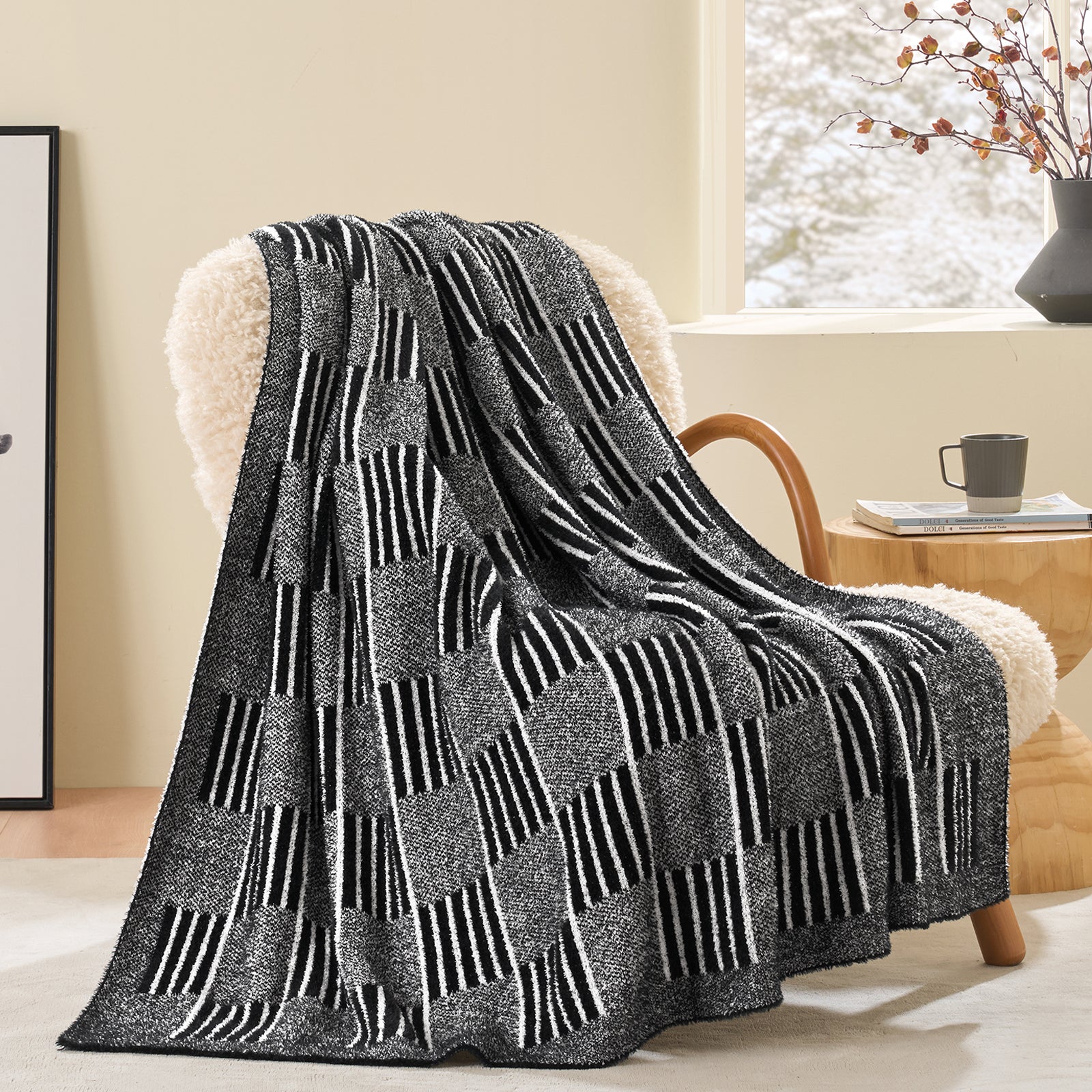 Black and white patterned throw blanket draped over a chair in a cozy living room.  #color_Heather Black