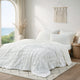 Snuggle Sac Cooling comforter in white on bed in a bedroom with window,plant and a view behind#color_White