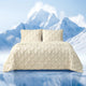 Snuggle Sac Cooling comforter in beige on bed in a bedroom with mountains in snow as a view behind#color_Beige