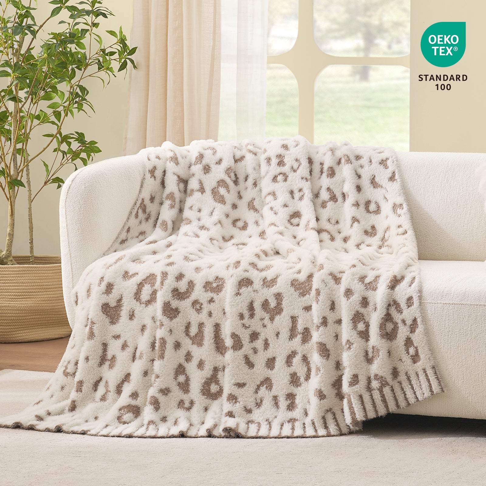 Leopard faux fur knit throw blanket in Leopard Beige draped over a sofa, showcasing soft texture and OEKO TEX STANDARD 100 certification #color_Leopard Beige