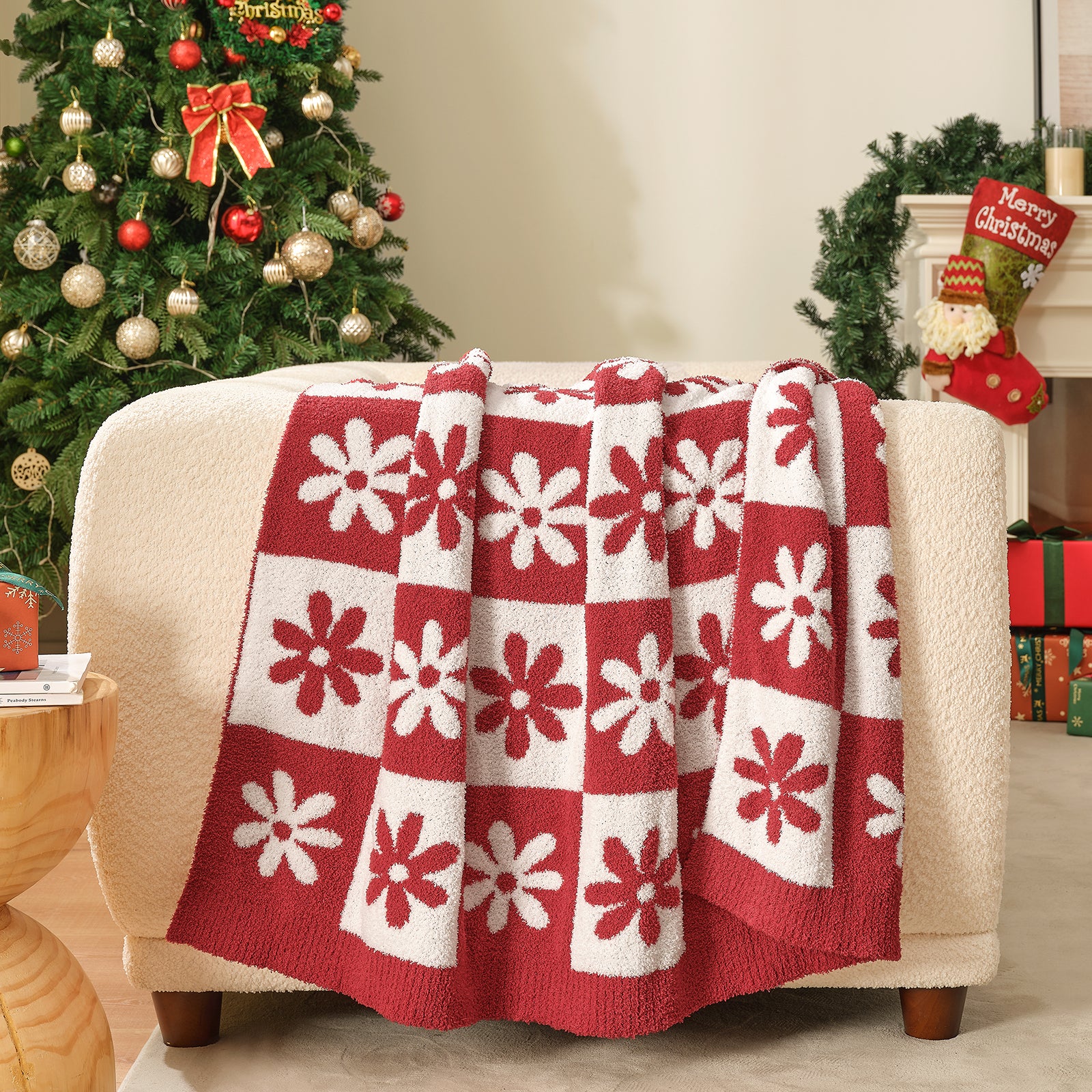 Red and white patterned blanket draped over a chair with a decorated Christmas tree in the background. #color_Xmas Green