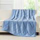 Blue cooling blanket draped over a beige sofa in a room with large windows.#color_Dark Blue