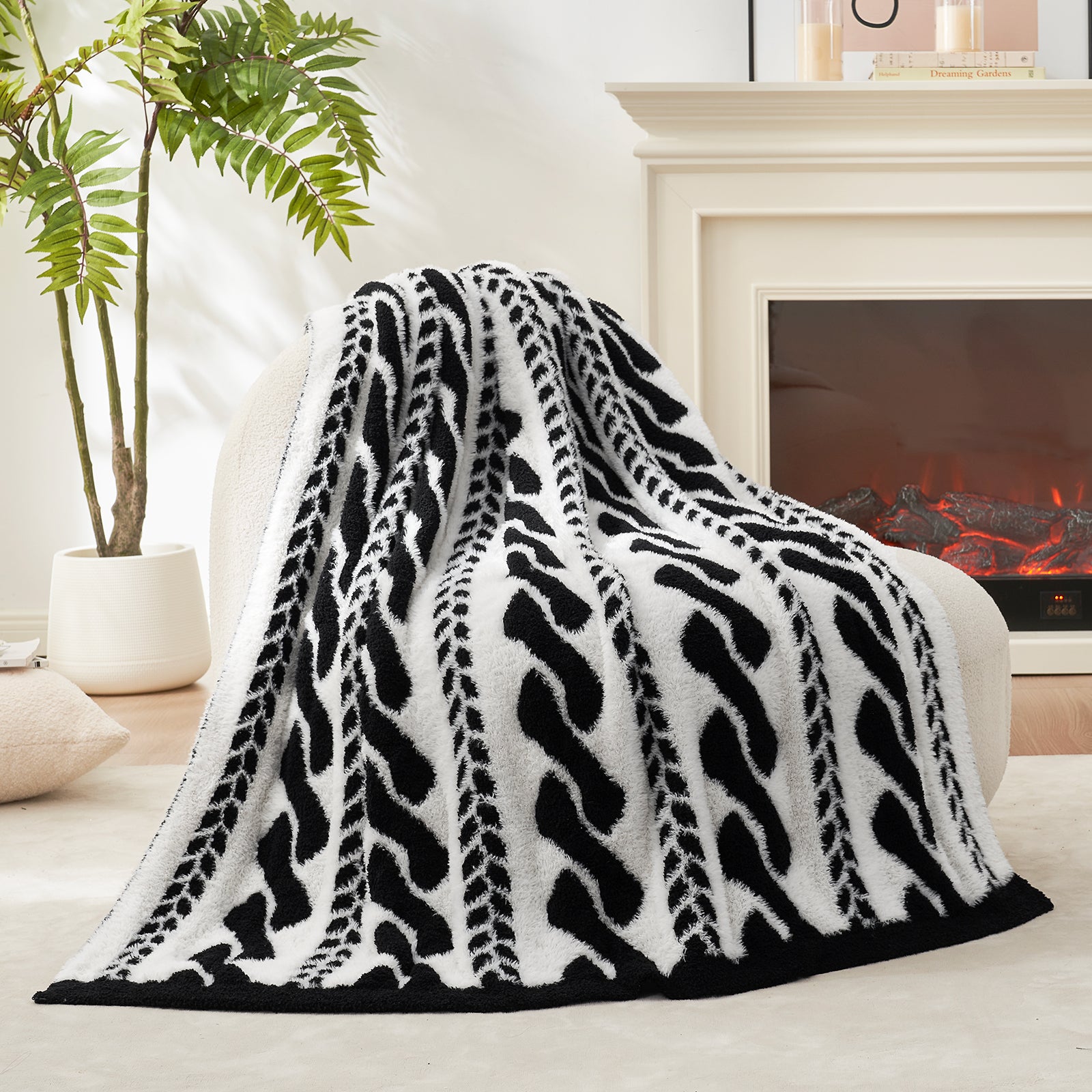 Cable pattern Faux Fur Knit Throw Blanket in black and white showing the back side.#color_Black