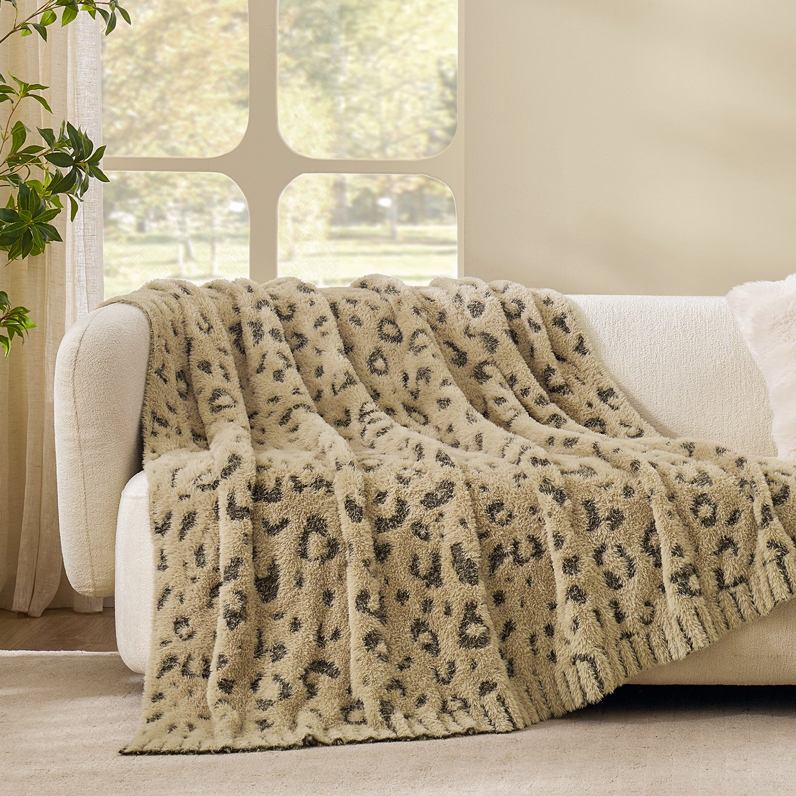 Leopard faux fur knit throw blanket in Brown Leopard draped over a sofa, showcasing soft texture #color_Brown Leopard