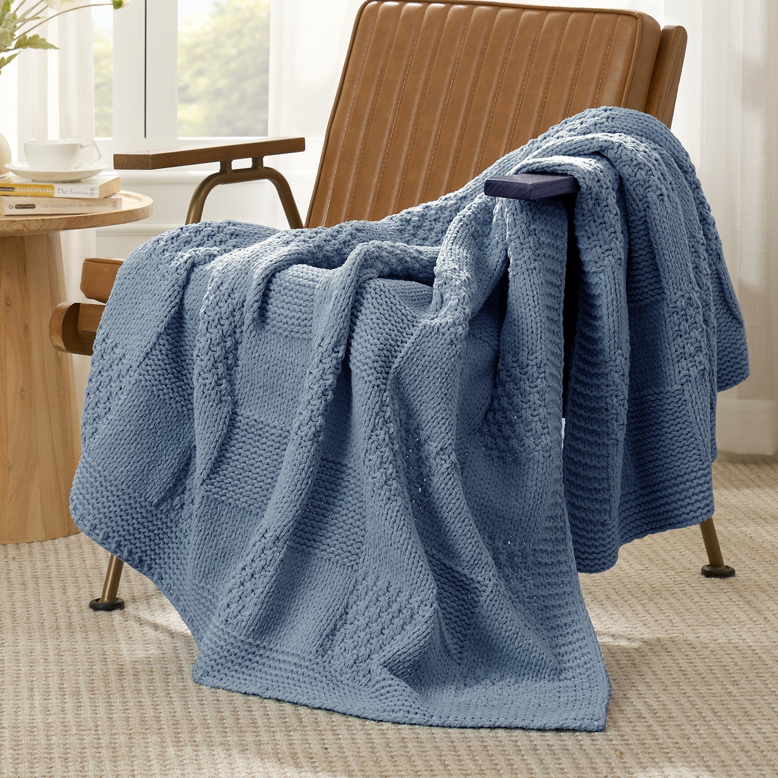Blue textured blanket draped over a brown armchair in a cozy room. #color_Washing Blue