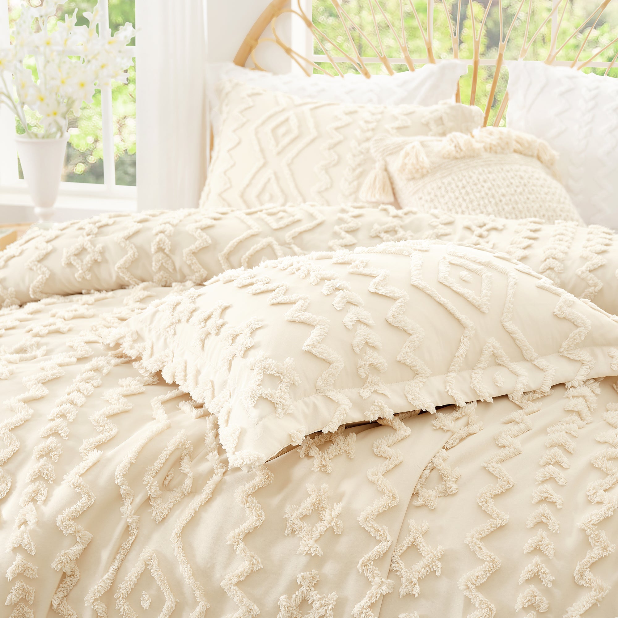 Beige textured comforter on a bed with pillows in a bright room.#color_Beige