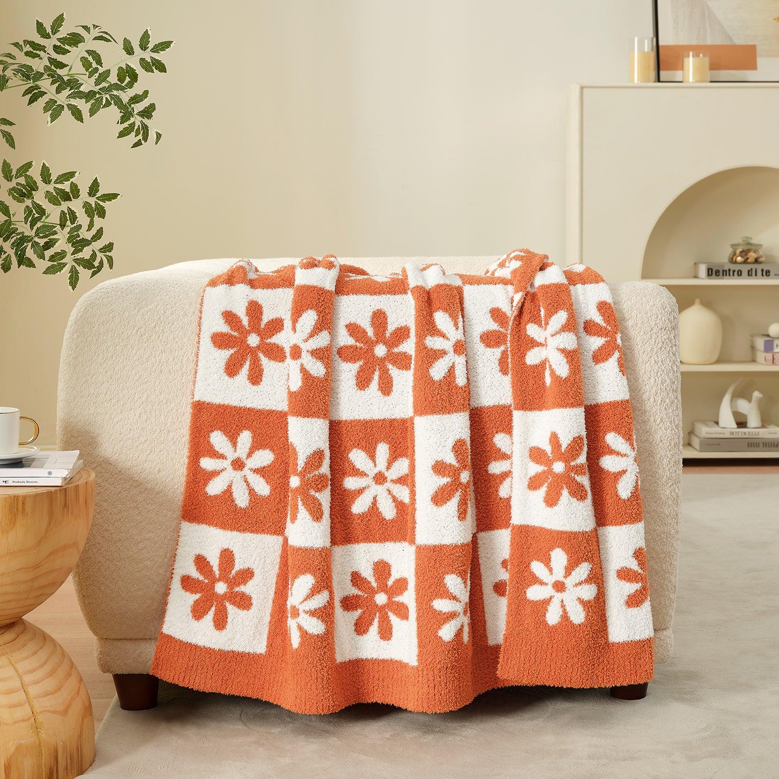Floral patterned blanket draped over a chair in a cozy living room. #color_Orange