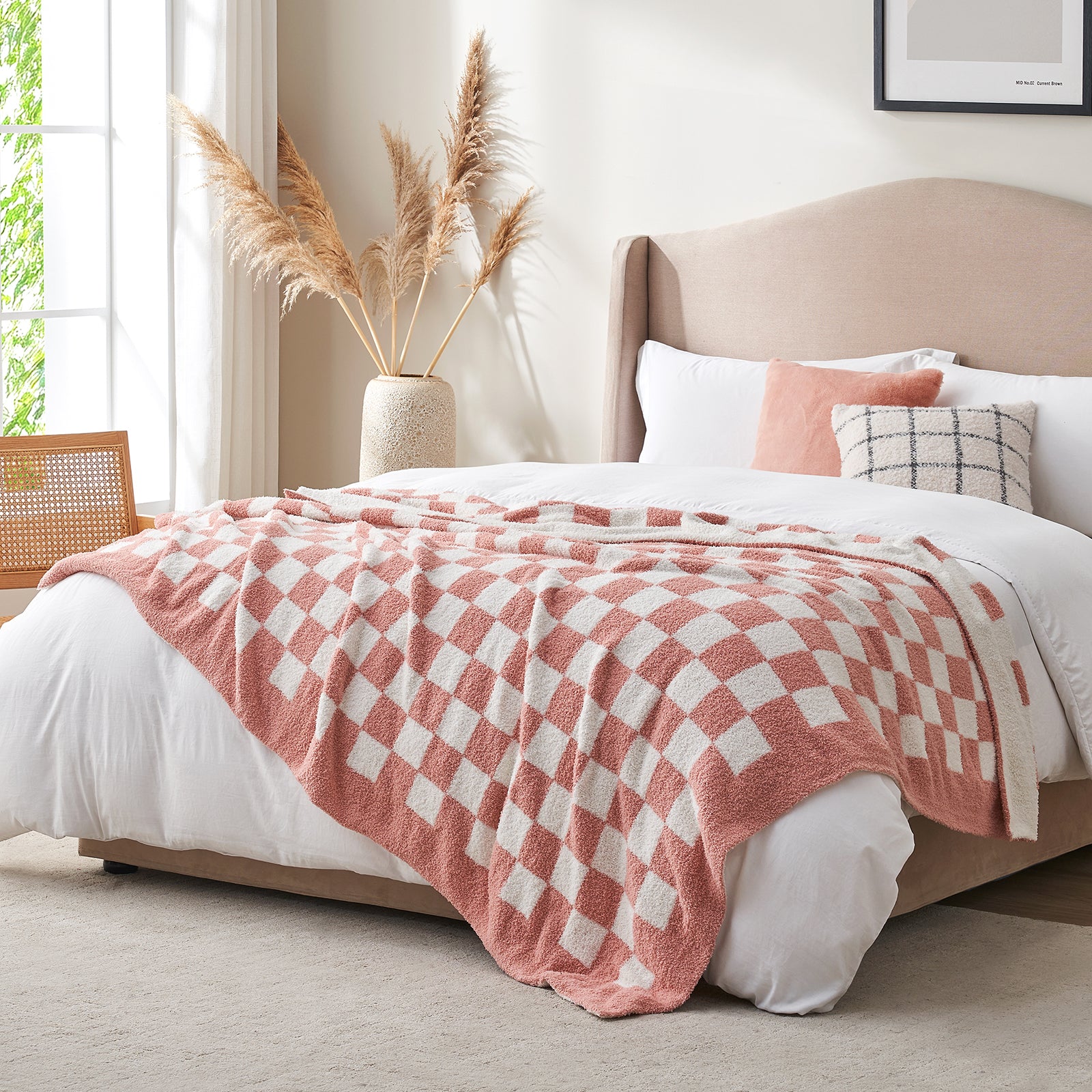 Bedroom with a bed featuring a pink checkered blanket and decorative pillows. #color_Checkered Pink