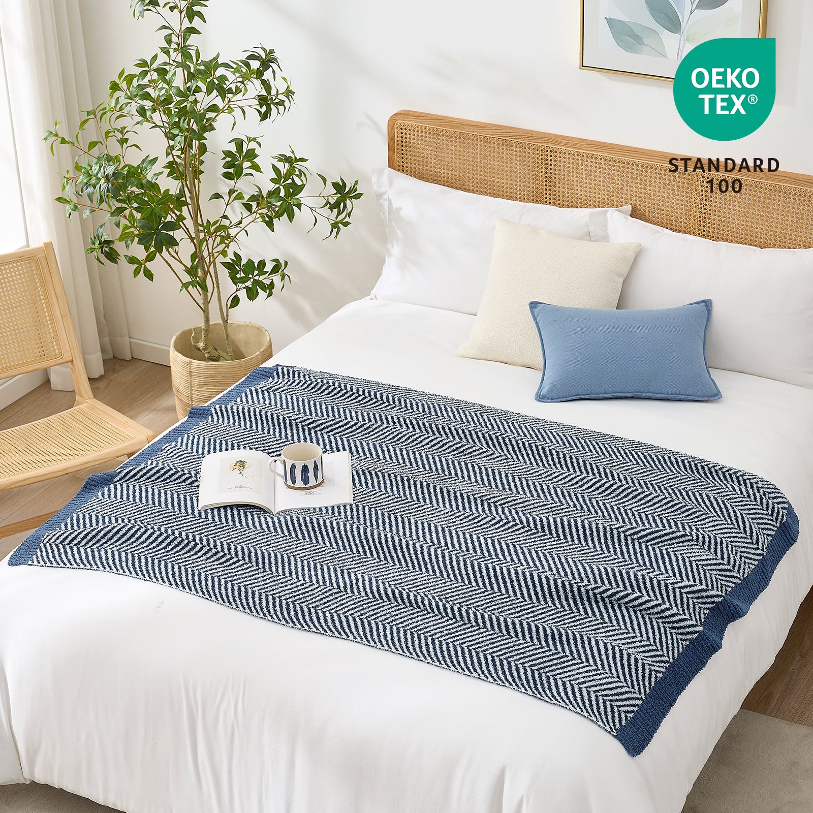 Snuggle Sacs Herringbone Feather Yarn Knit Throw Blanket on the bed with a magazine and tea cup on the blanket#color_Navy