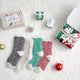 Snuggle Sac women heather plain socks 4 pairs in Red/Green/Black/White displayed in a cozy holiday gift setting #color_Red/Green/Black/White