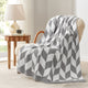 Snuggle Sacs Chevron Feather Yarn Knit Throw Blanket on the chair with lamp and window behind#color_Grey
