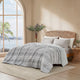 Snuggle Sac cationic dyed striped seersucker cooling comforter in Light Grey layered on a bed #color_Light Grey