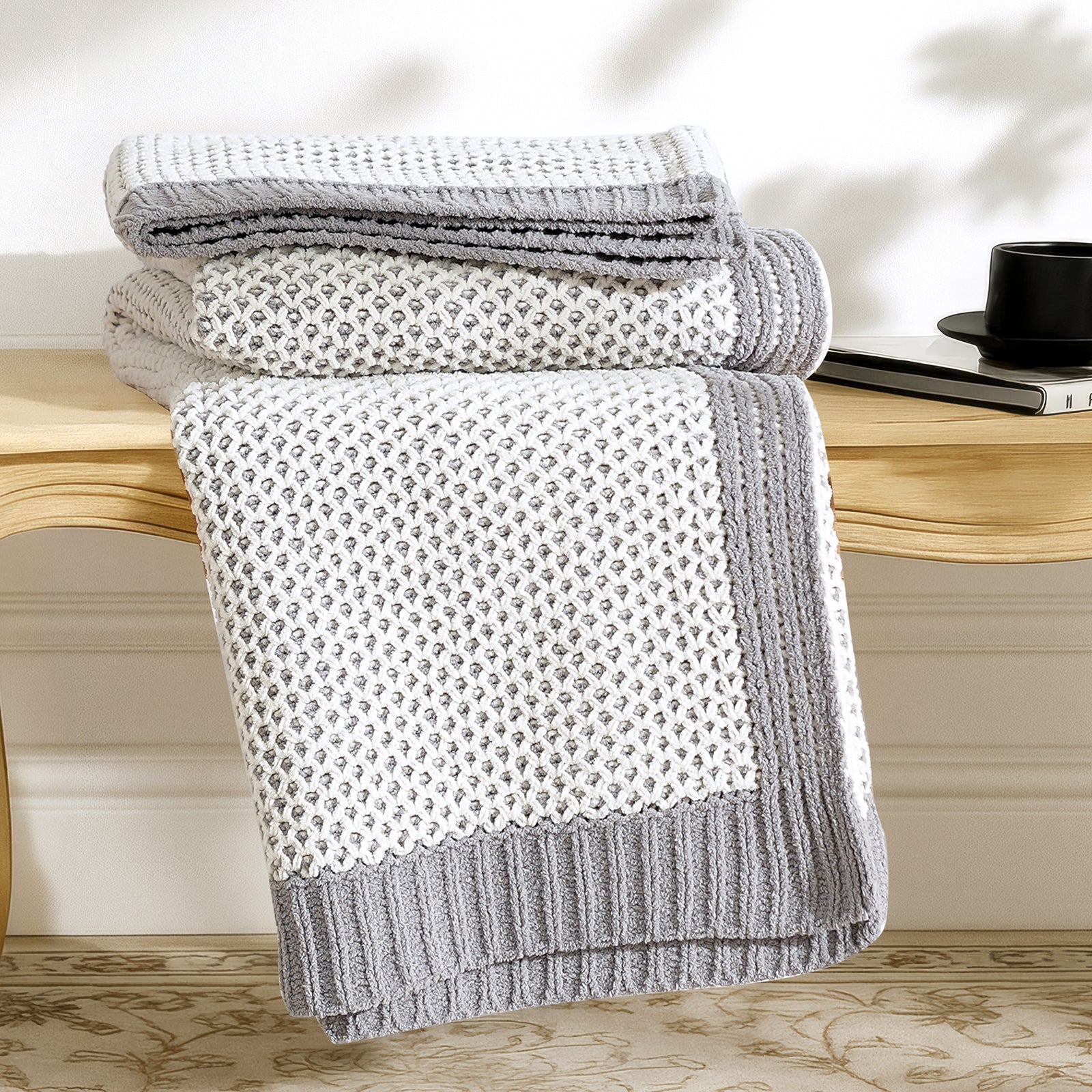 Two tone honeycomb chenille knit throw blanket in Grey and White neatly folded on a wooden table showcasing texture #color_Grey