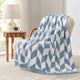 Snuggle Sacs Chevron Feather Yarn Knit Throw Blanket on the chair with lamp and window behind#color_Blue