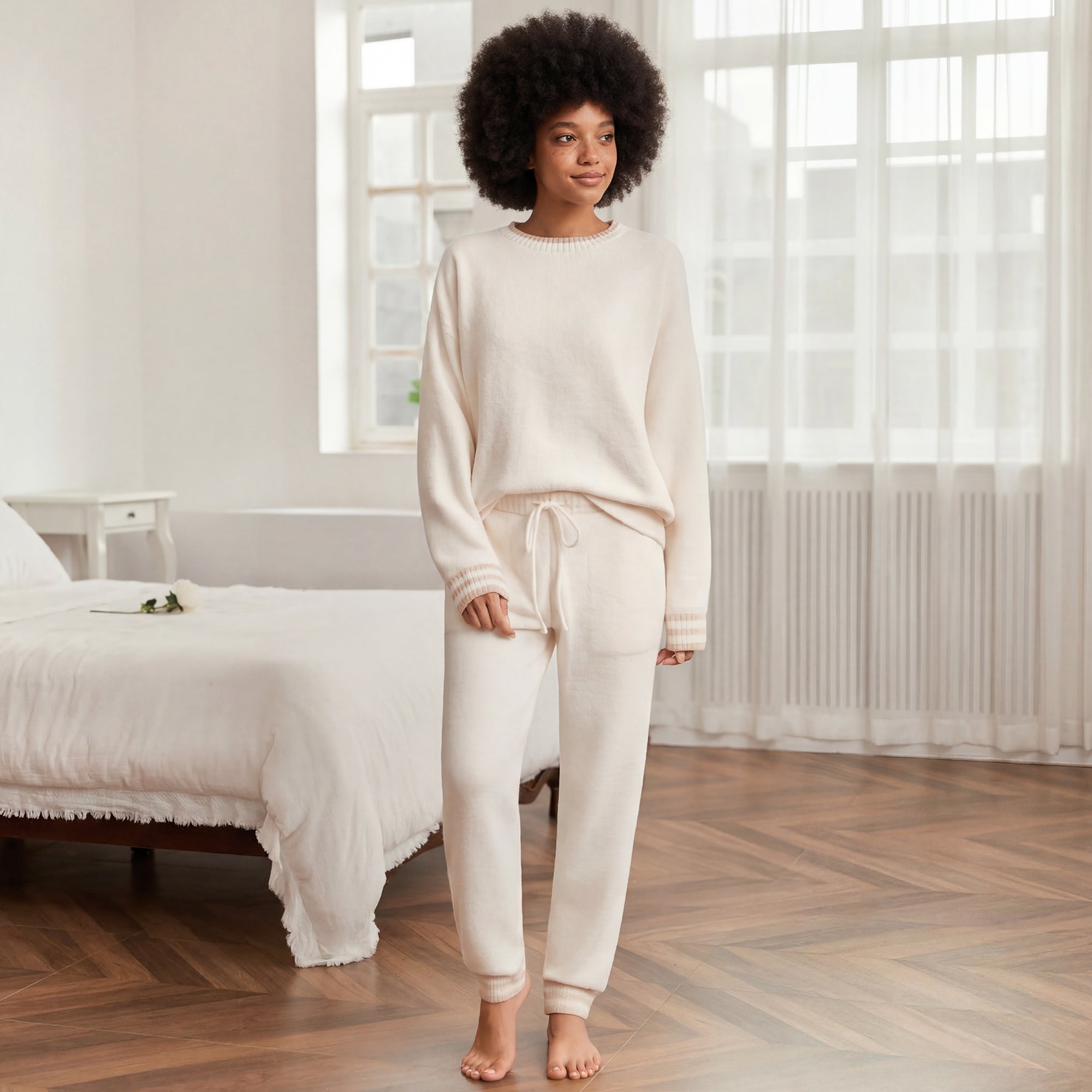 Woman in Snuggle Sac cream-colored outfit standing in a bedroom. #color_Ivory