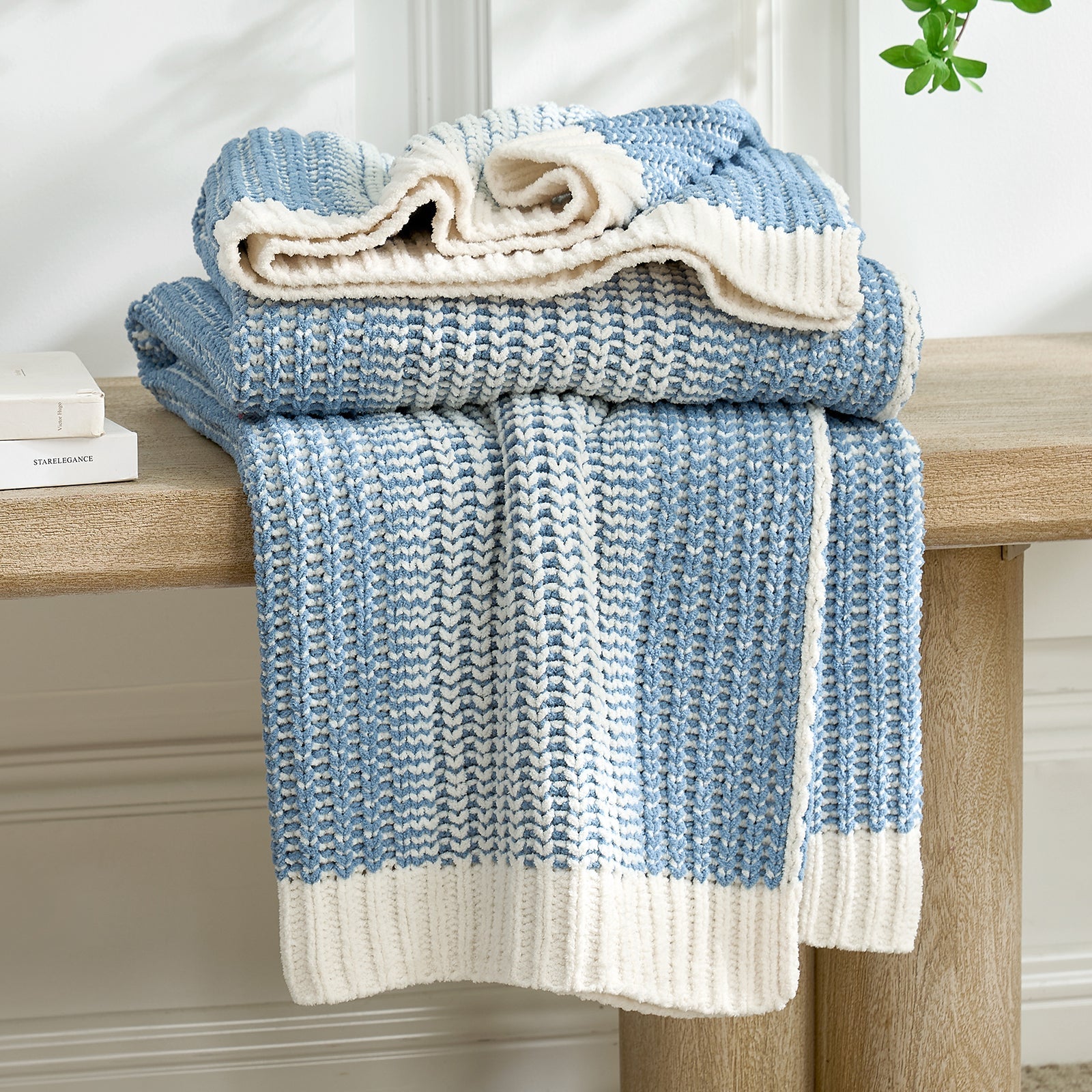 Stack of blue and white textured towels on a wooden surface with a neutral background #color_Two-tone Blue