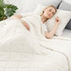 Woman sleeping under a Snuggle Sac white comforter in a cozy bedroom setting.   #color_White