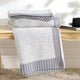 Stack of Snuggle Sac gray textured towels on a wooden surface with a blurred background #color_Gray&White