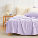 Bed with purple Snuggle Sac cooling comforter and pillows in a bedroom setting.#color_Purple