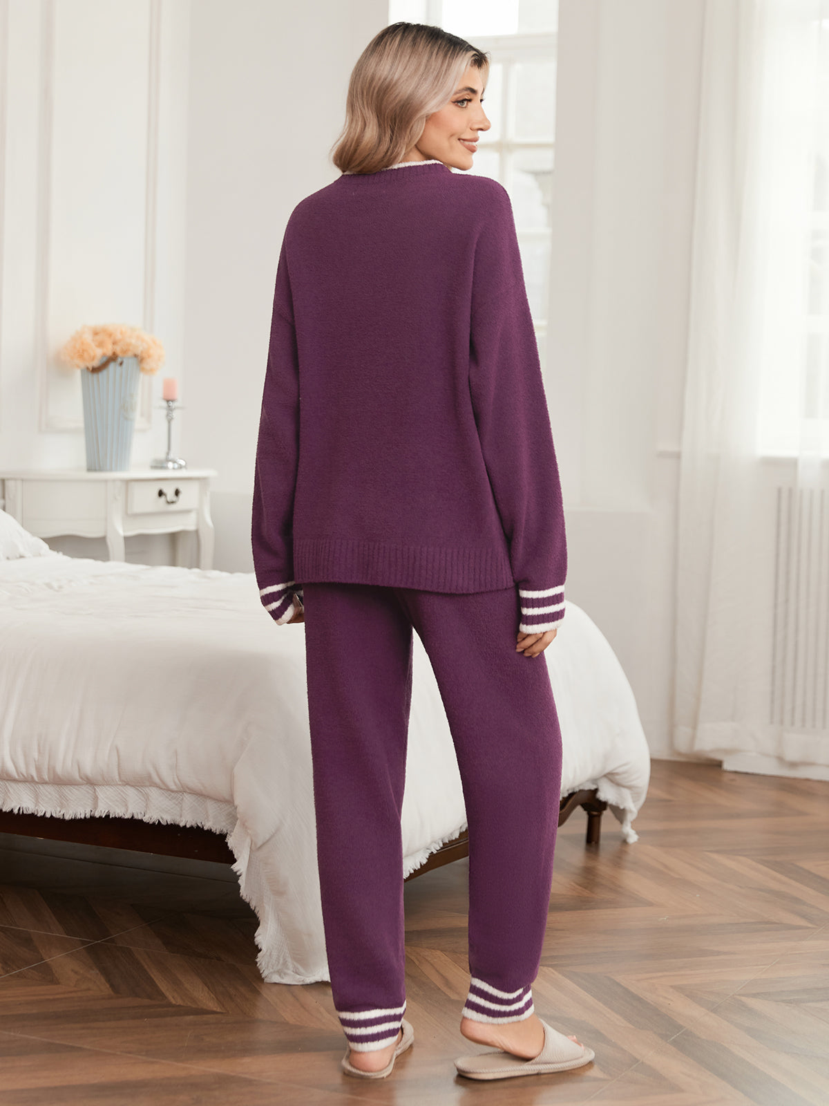 Woman wearing a purple pajama set in a bedroom.  #color_Purple