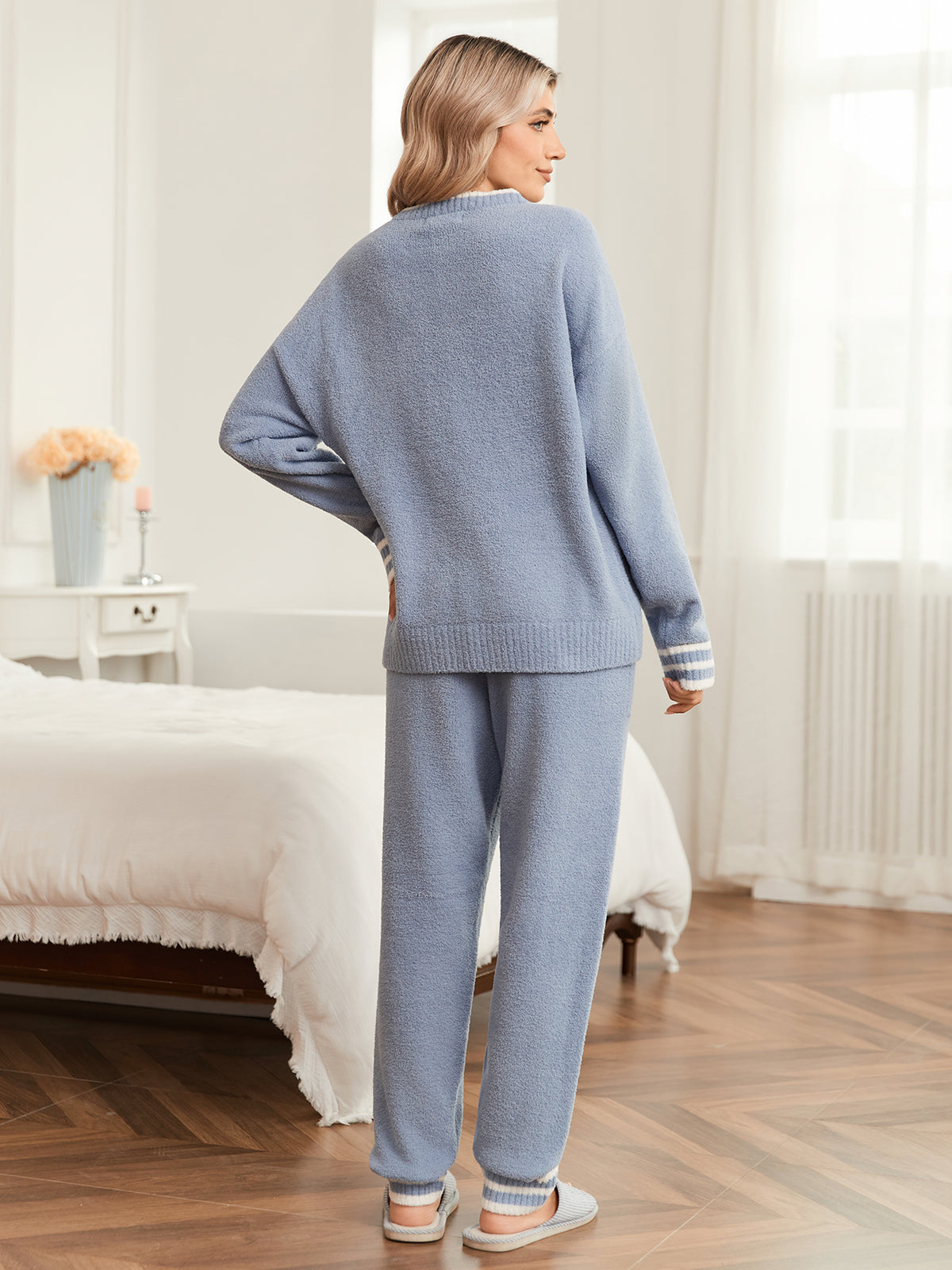 Woman wearing a blue pajama set in a bedroom. #color_Blue