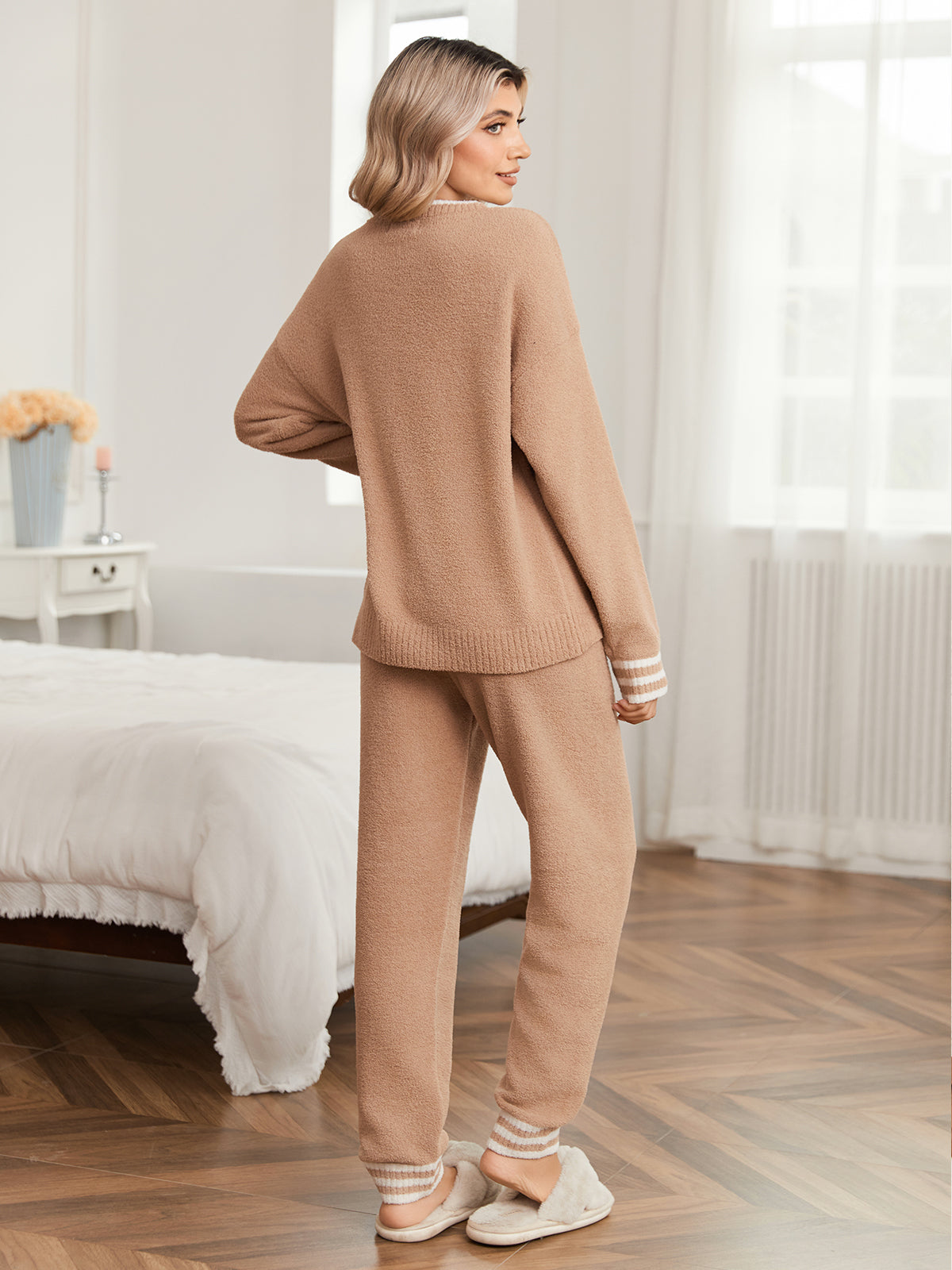 Woman wearing a beige lounge set in a cozy bedroom. #color_Khaki