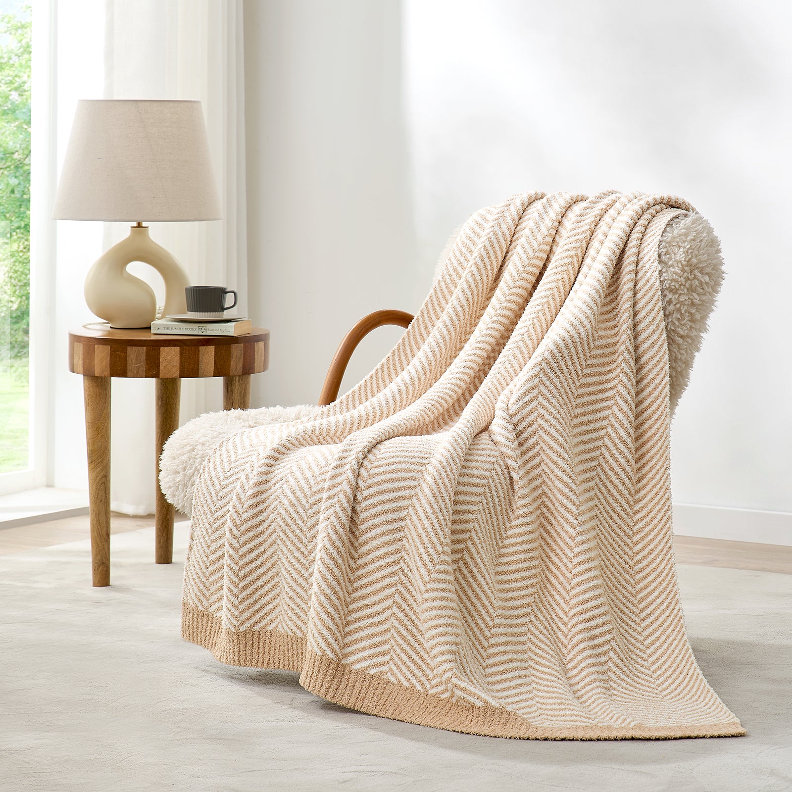 Snuggle Sacs Herringbone Feather Yarn Knit Throw Blanket on the chair with window and plant behind#color_Beige