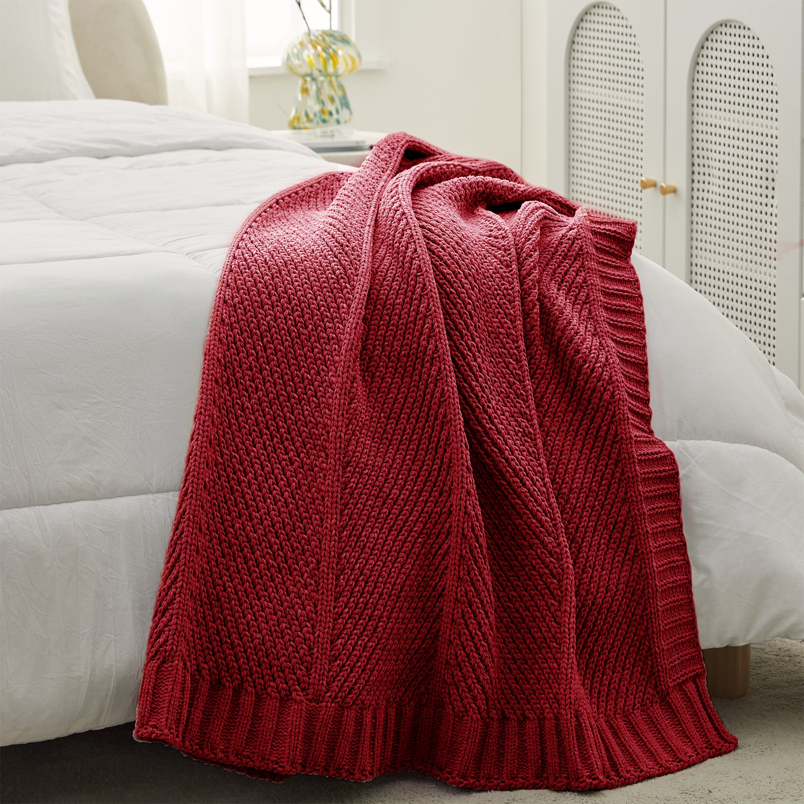 Chevron chenille knit throw blanket in Red placed at the foot of a bed adding texture and warmth #color_Red
