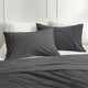 Grey Snuggle Sac bedding set on a bed with white pillows and headboard.#color_Charcoal Grey