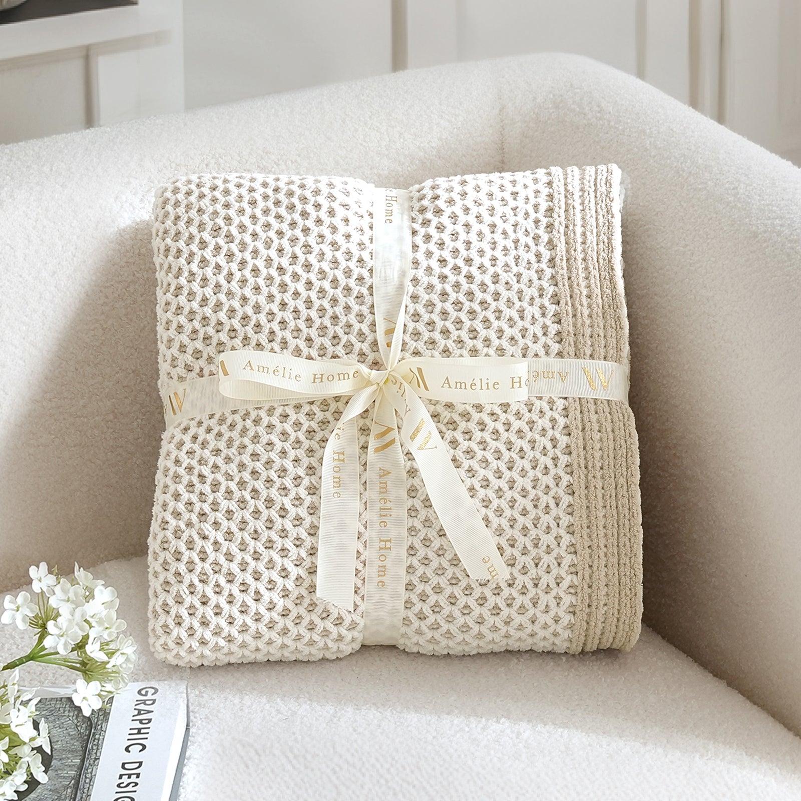 Folded beige blanket with a ribbon on a white surface #color_Khaki&White
