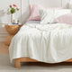 Bed with Snuggle Sac cream white cooling comforter and pillows in a bedroom setting.#color_Cream White