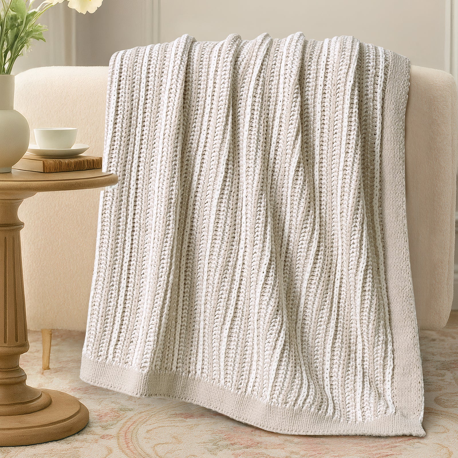 Textured blanket draped over a sofa in a cozy living room setting. #color_Khaki&White