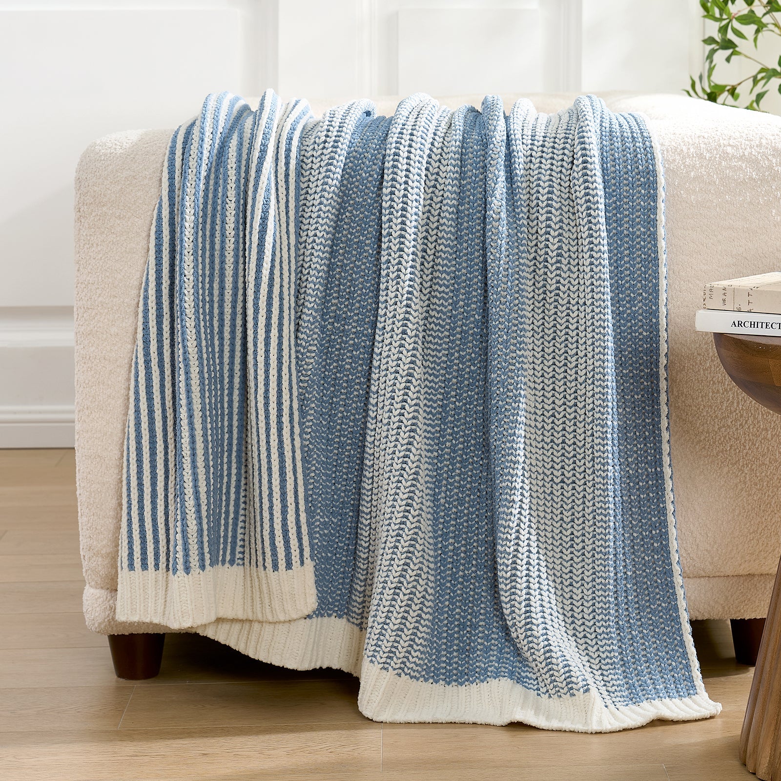 Snuggle Sac blue and white striped blanket draped over a beige armchair in a room with light-colored walls. #color_Two-tone Blue