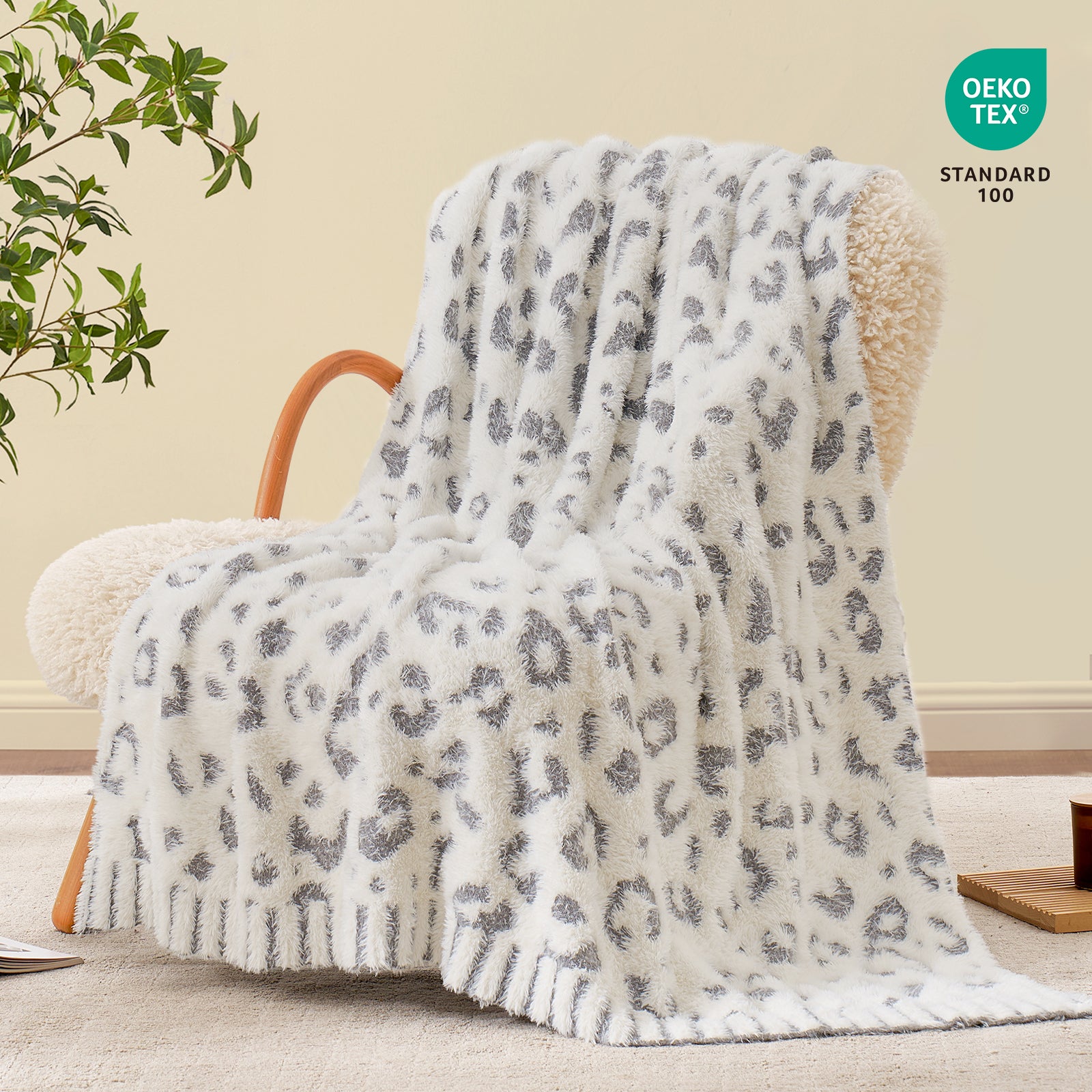 Snuggle Sac leopard faux fur knit throw blanket in Grey Leopard draped over an armchair, creating a cozy and stylish living corner #color_Grey Leopard