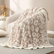Reversible Leopard Feather Yarn Knit Throw Blanket on a beige couch in a bright room #Color_Leopard Beige