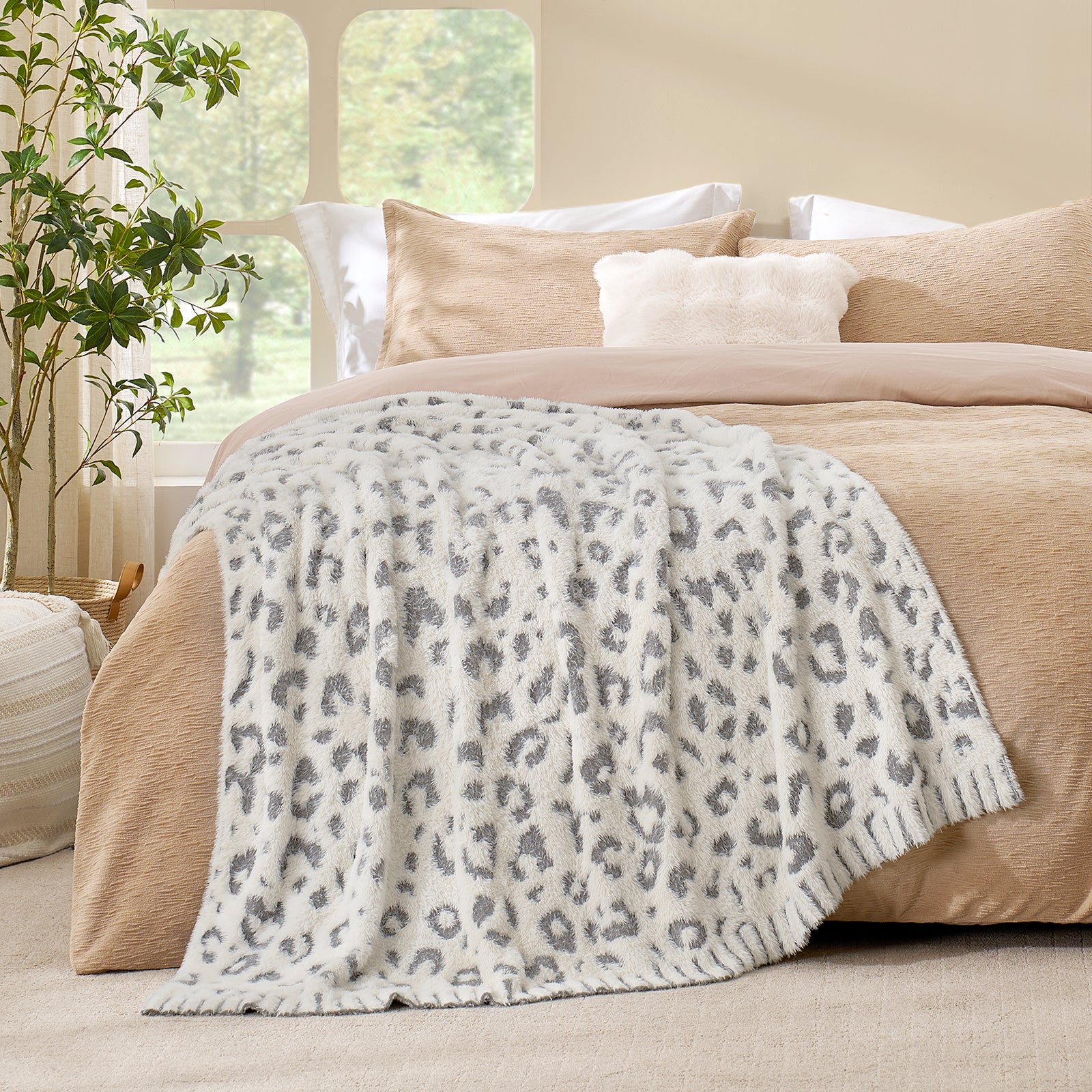 Grey Leopard faux fur knit throw blanket layered on a bed, creating a warm and inviting bedroom look #color_Grey Leopard